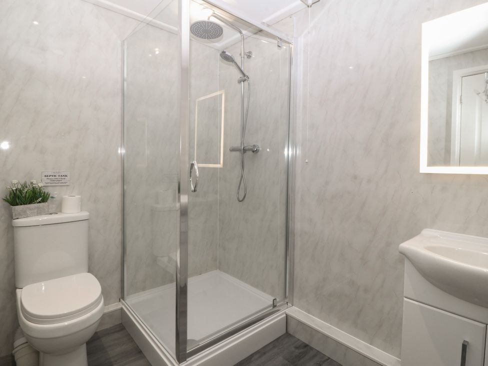 A bathroom with a shower, toilet, and sink at Red Wharf Retreat in Red Wharf Bay near Benllech