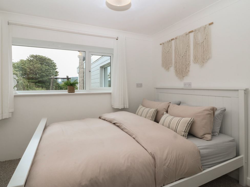A bedroom with a bed and window at Red Wharf Retreat Red Wharf Bay near Benllech