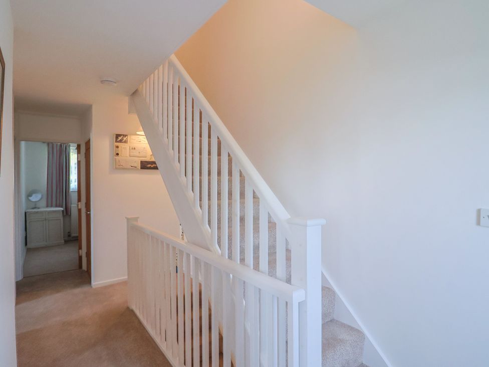 A hallway with a staircase and a door at Seaview in Lyme Regis