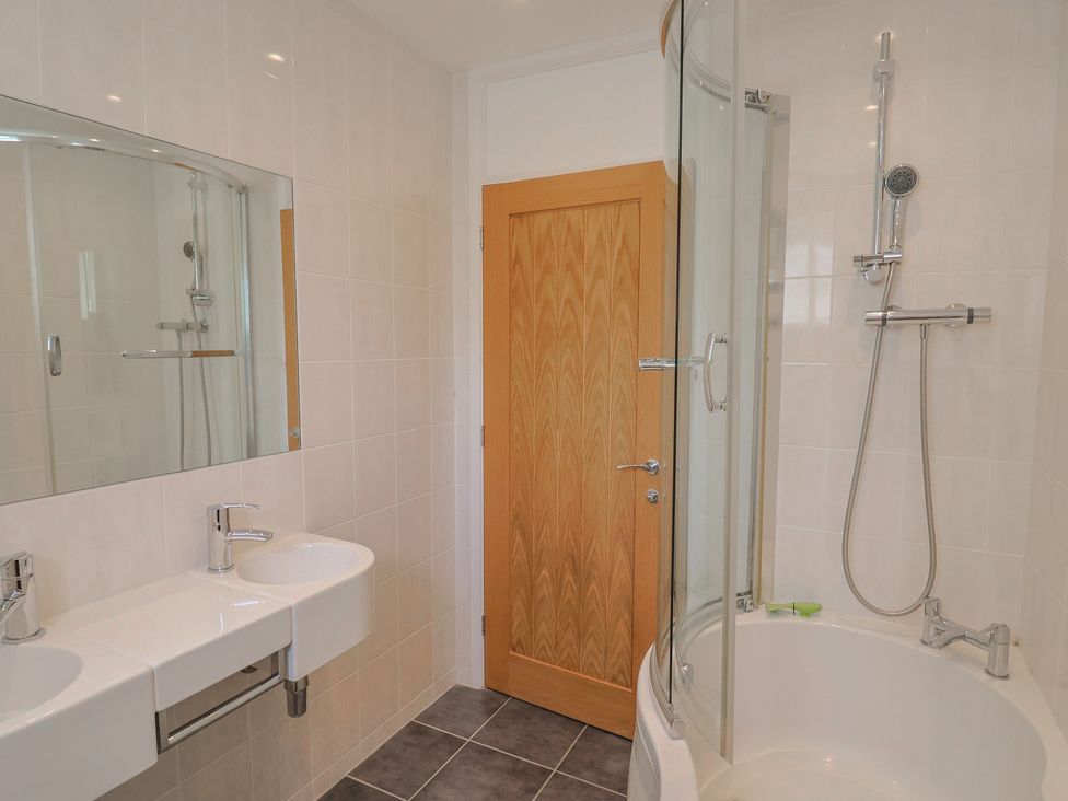 A bathroom with a shower and two sinks at Seaview in Lyme Regis