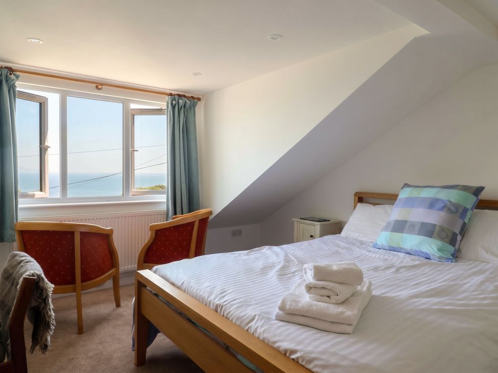 A bedroom with bed and chairs at Seaview in Lyme Regis