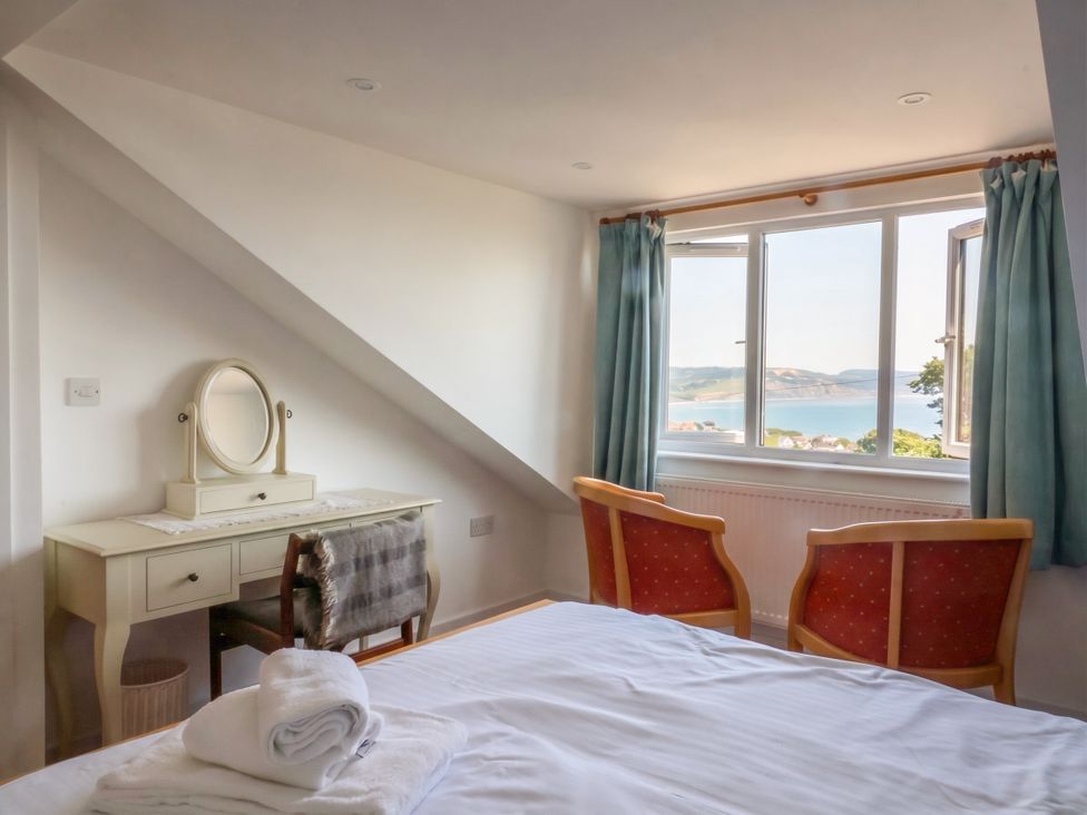 A bedroom with a view and furniture at Seaview in Lyme Regis