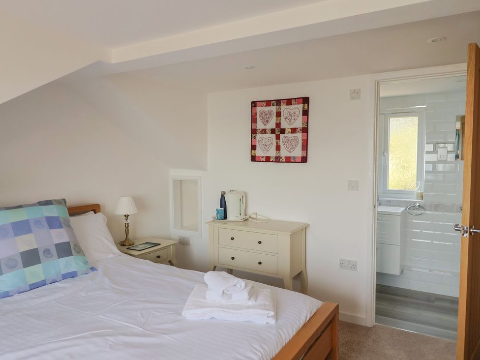 A bedroom with a bed and bathroom access at Seaview in Lyme Regis