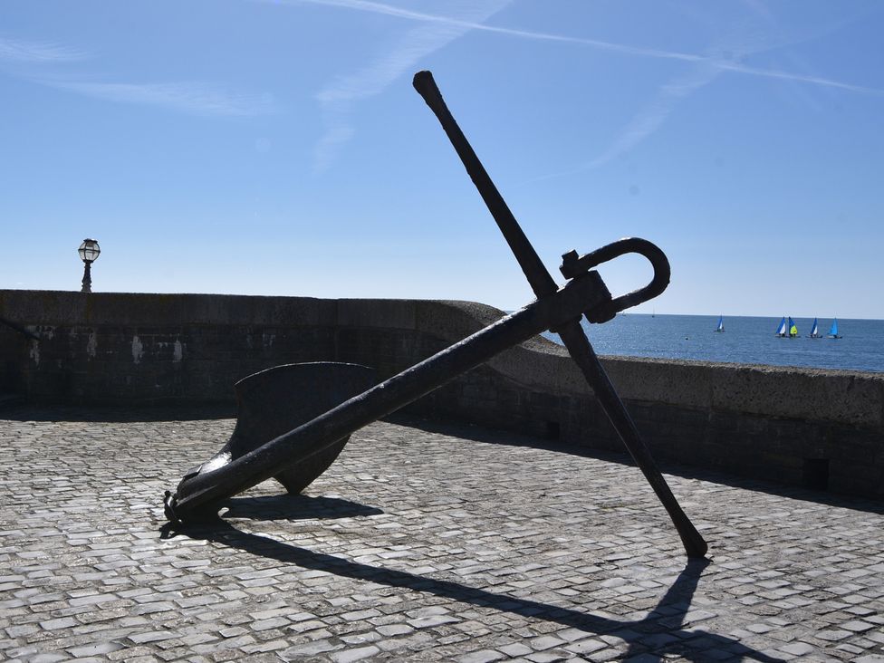 An anchor on cobblestones near the sea at Seaview in Lyme Regis