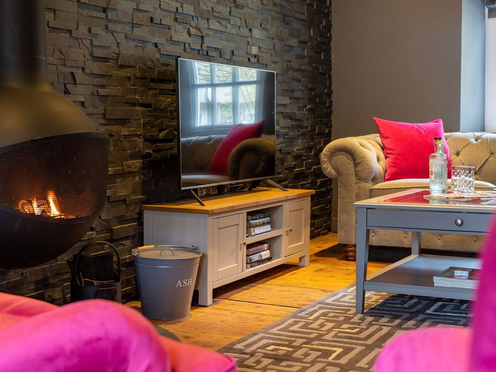 A living room with a fireplace and television at Prospect House in Windermere