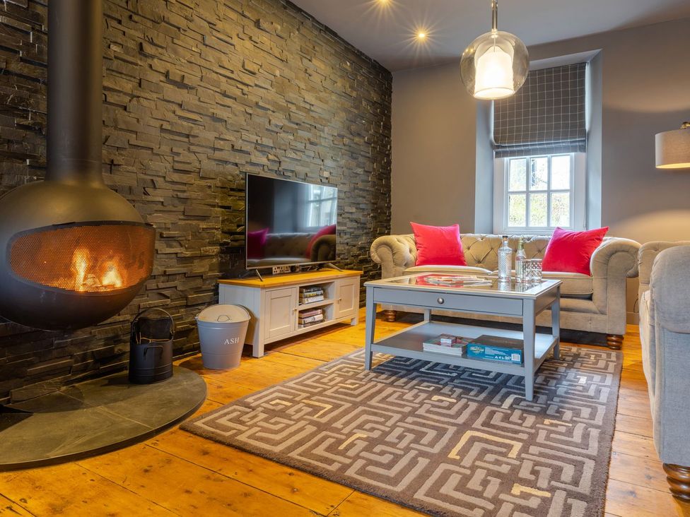 A living room with a fireplace and television at Prospect House in Windermere