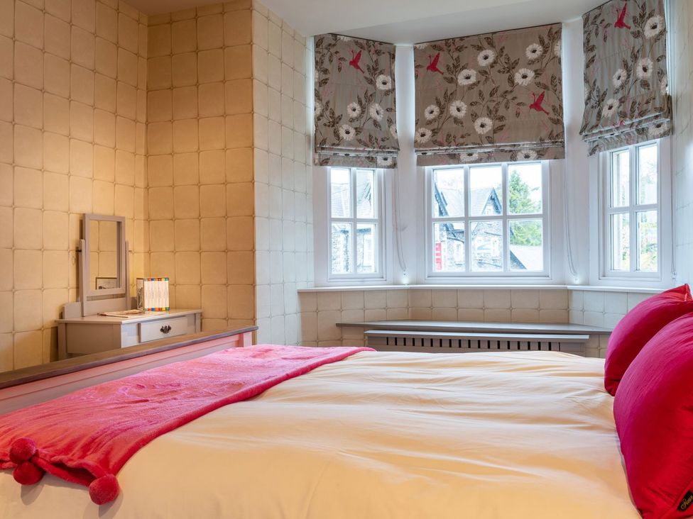 A bedroom with a bed and mirror at Prospect House in Windermere