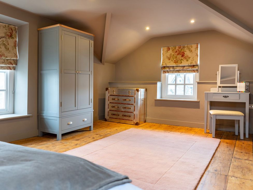 A bedroom with a wardrobe and desk at Prospect House in Windermere