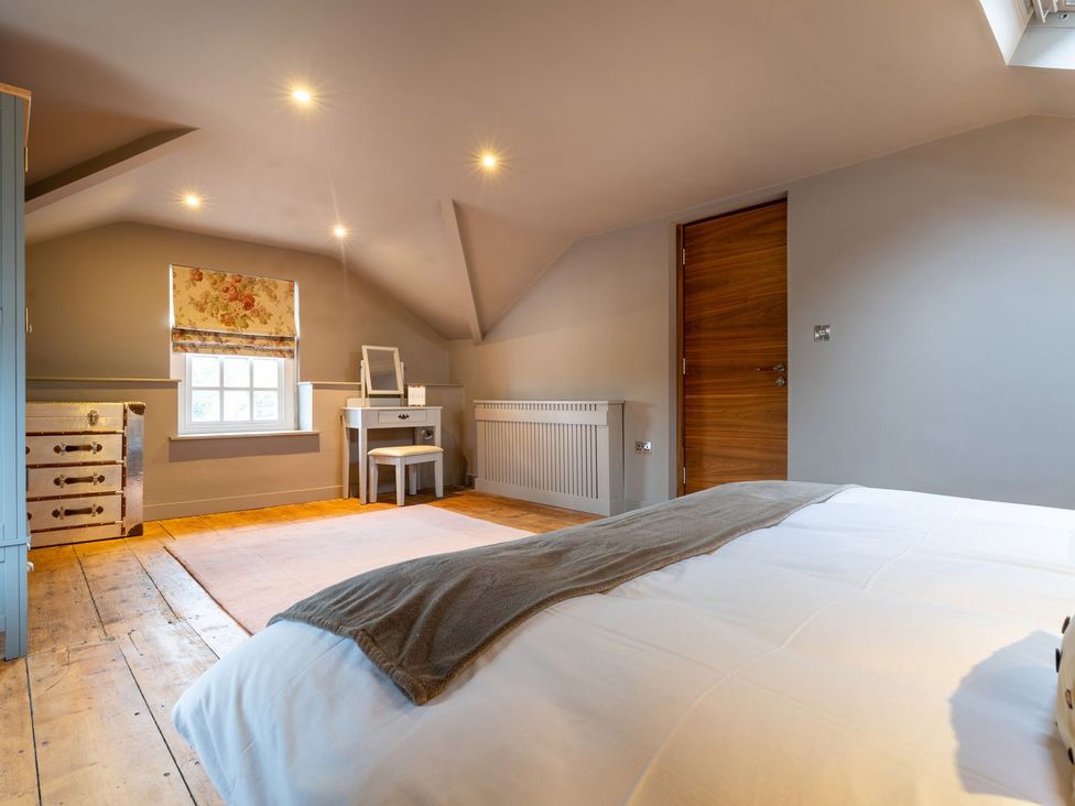 A bedroom with a bed, desk, and window at Prospect House in Windermere