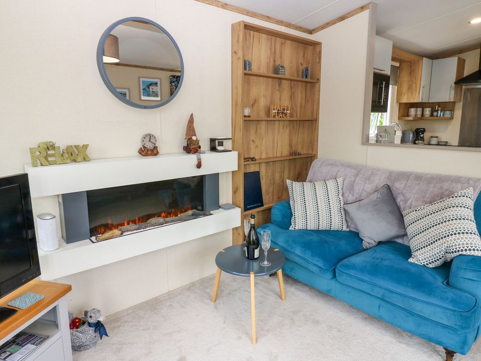 A living room with a blue sofa and a fireplace at Plot 41 High Hesket near Armathwaite
