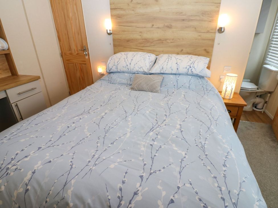 A bedroom with a bed and bedside table at Plot 41 in High Hesket near Armathwaite