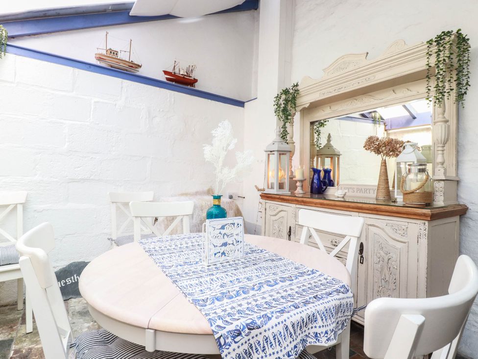 A dining room with a table and chairs at Stones Throw in Mevagissey