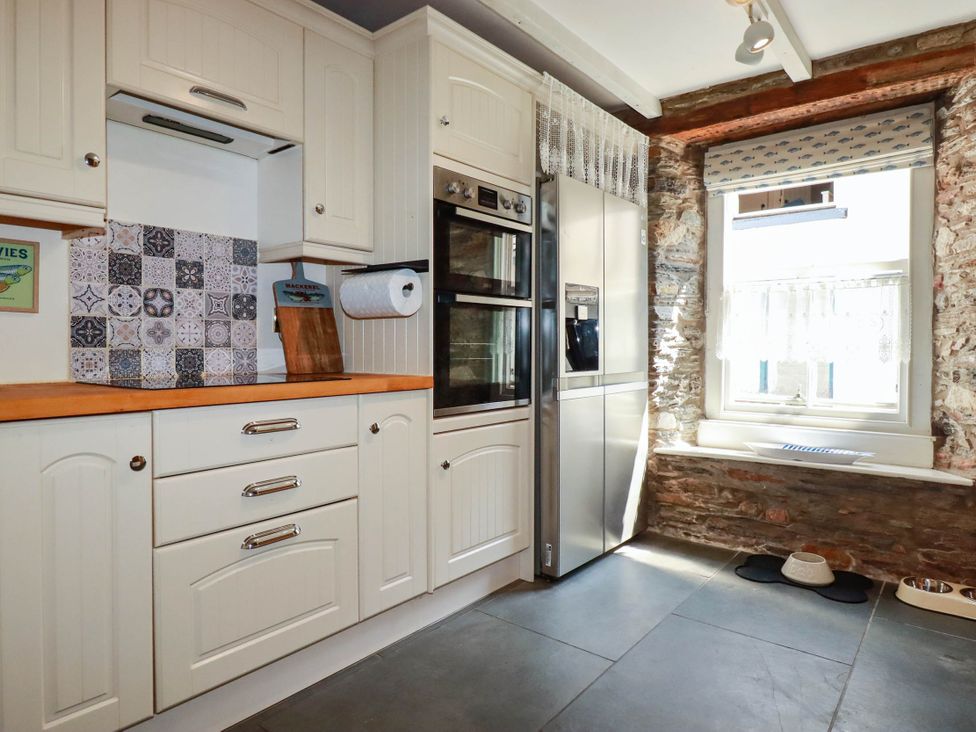 A kitchen with cabinets and appliances at Stones Throw Mevagissey