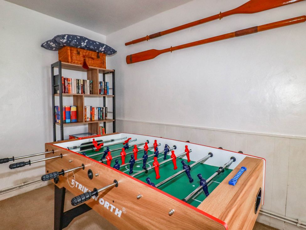 A game room with a foosball table and a bookshelf at Stones Throw in Mevagissey