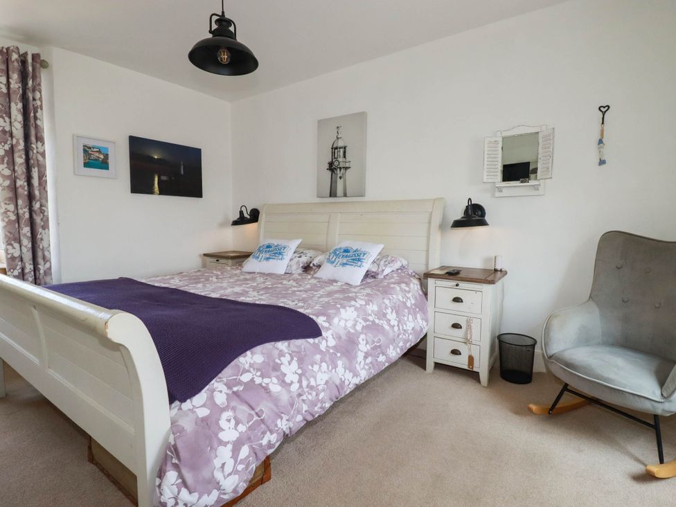 A bedroom with a bed and bedside lamps at Stones Throw in Mevagissey