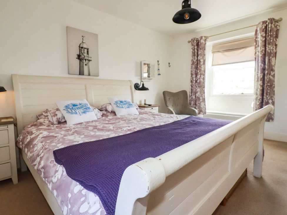 A bedroom with a double bed and bedside table at Stones Throw Mevagissey