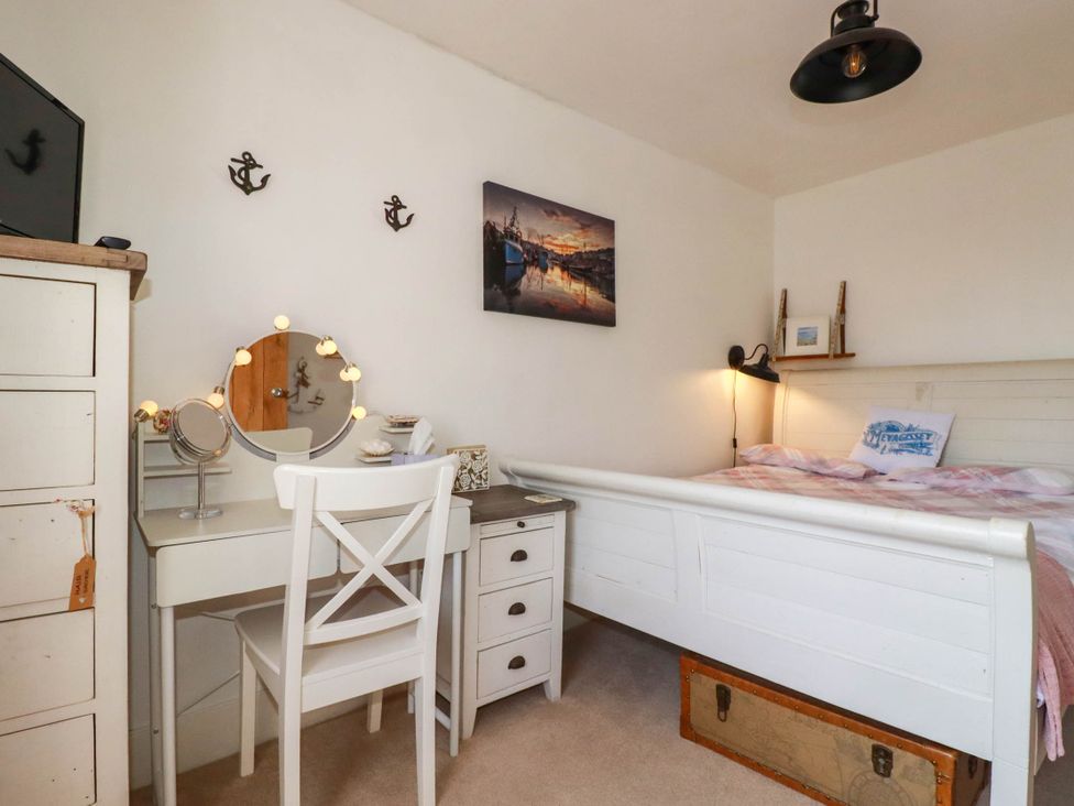 A bedroom with a bed and dressing table at Stones Throw in Mevagissey