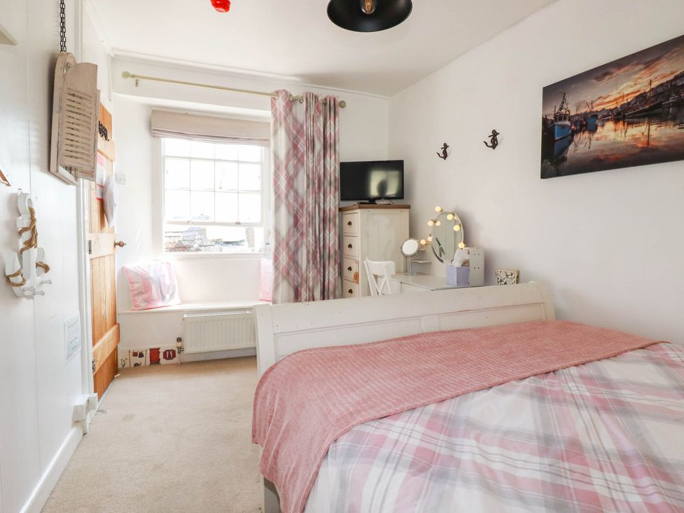 A bedroom with a bed and television at Stones Throw in Mevagissey