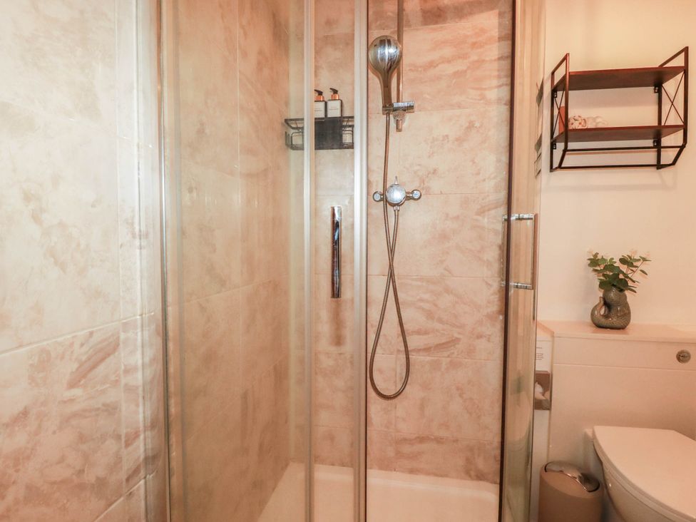 A shower with glass doors in a bathroom at Stones Throw in Mevagissey