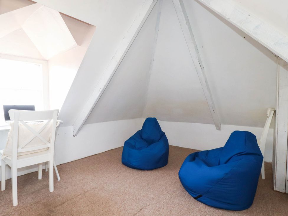 An attic with two blue bean bags and a chair at Stones Throw in Mevagissey
