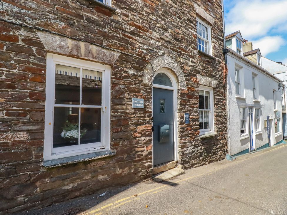 An exterior view of a stone building with windows and a door at Stones Throw in Mevagissey