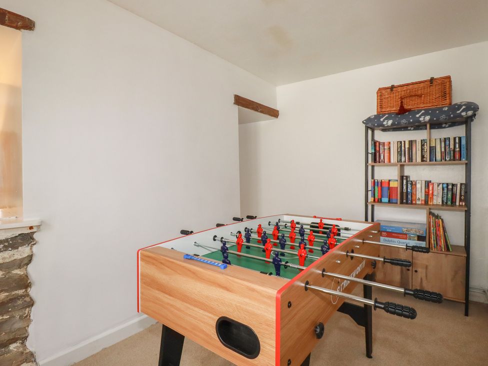 A game room with a foosball table and a bookshelf at Stones Throw in Mevagissey