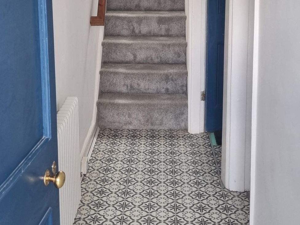 A hallway with a staircase and tiled floor at 3 Greystone Terrace in Cleator Moor