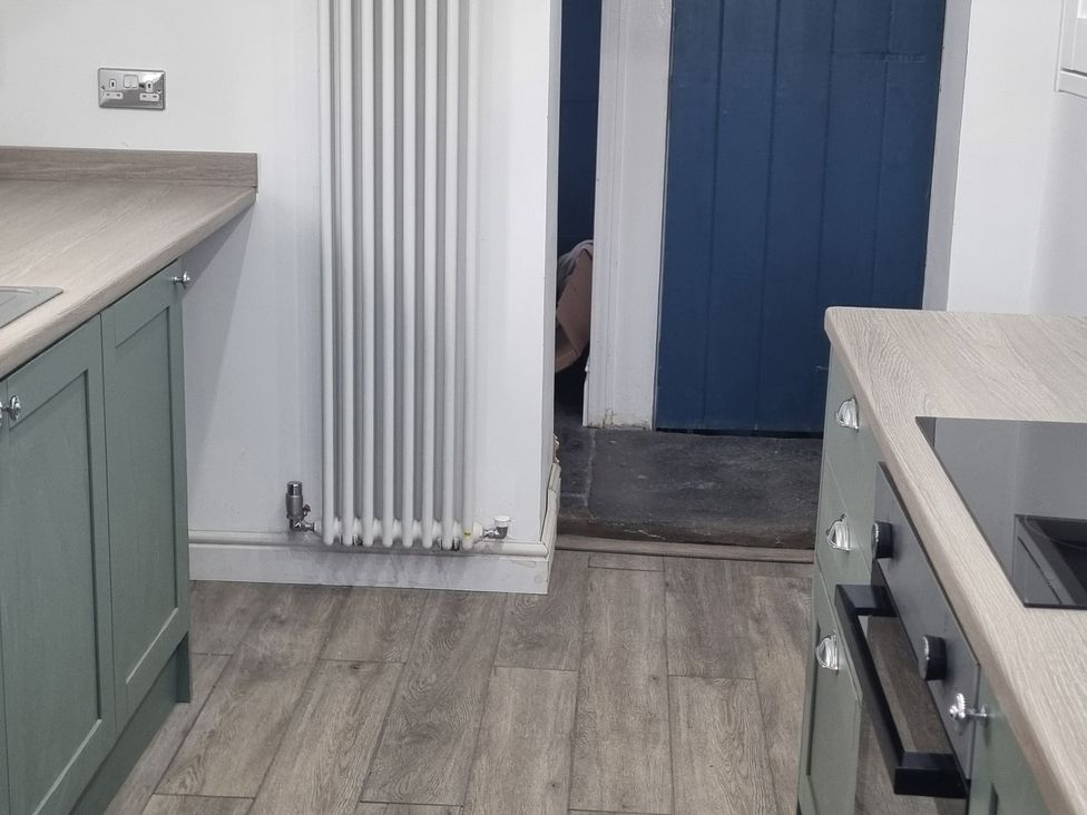 A kitchen with a countertop and radiator at 3 Greystone Terrace, Cleator Moor