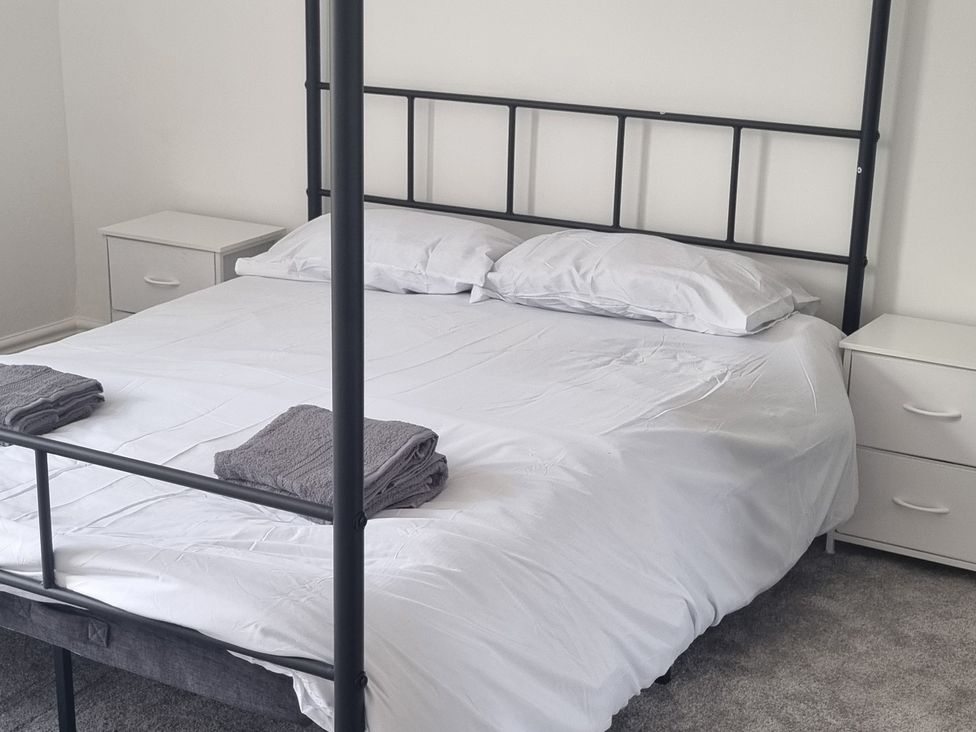 A bedroom with a bed and nightstands at 3 Greystone Terrace Cleator Moor