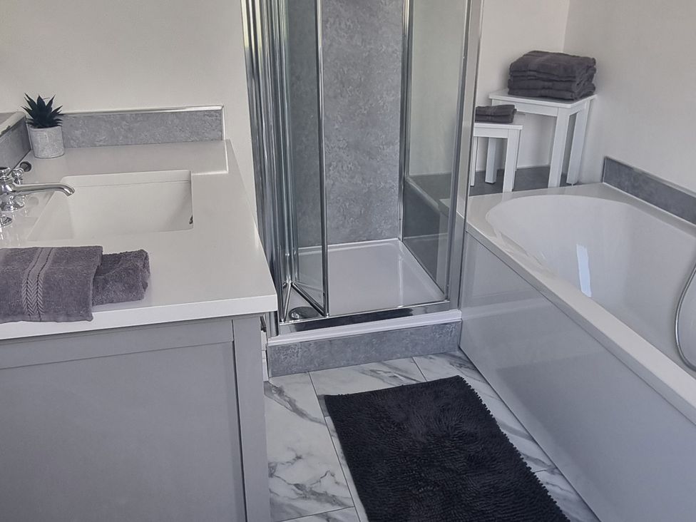 A bathroom with sink, shower, and bathtub at 3 Greystone Terrace Cleator Moor