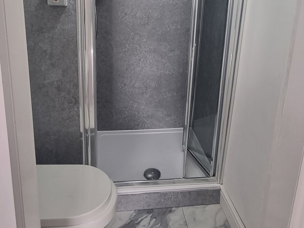 A bathroom with a shower and toilet at 3 Greystone Terrace in Cleator Moor