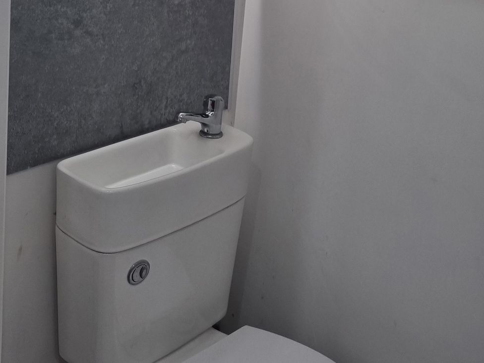 A bathroom with a toilet and sink at 3 Greystone Terrace in Cleator Moor