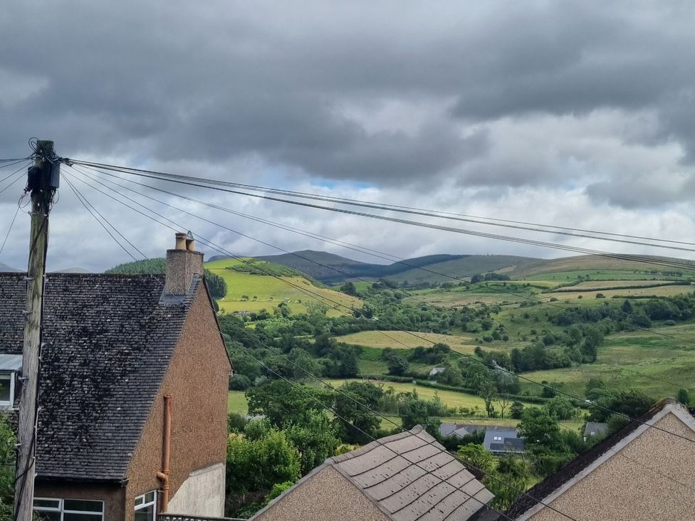 A view of hills and fields with a house and power lines in Cleator Moor