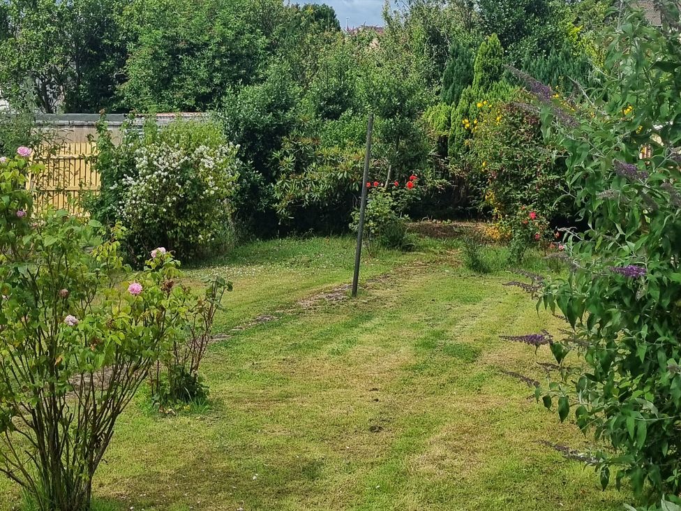 A garden with flower bushes and trees at 3 Greystone Terrace Cleator Moor