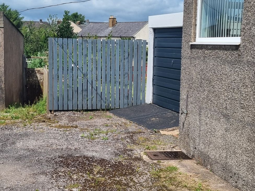 An outdoor space with a fence and garage at 3 Greystone Terrace in Cleator Moor