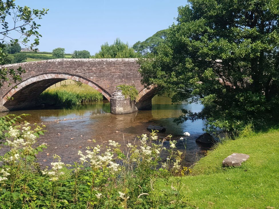 A bridge over water with greenery at 3 Greystone Terrace in Cleator Moor