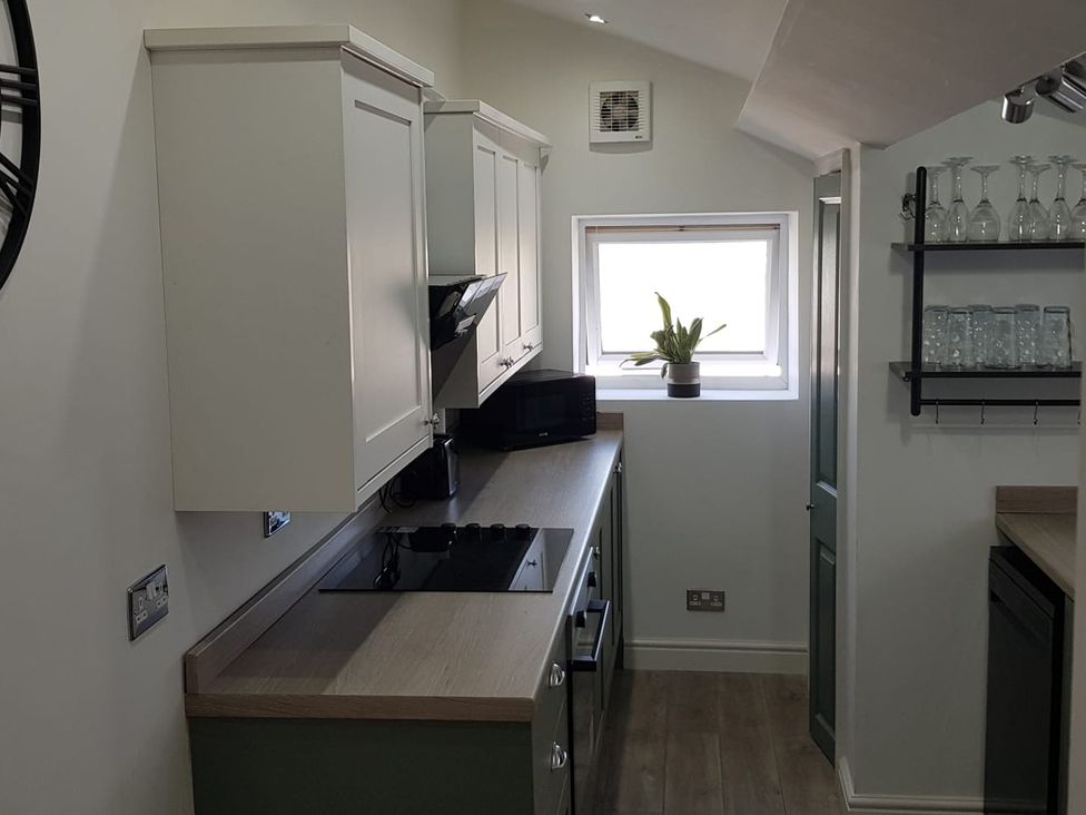 A kitchen with cabinets and a stove at Ehen Cottage in Cleator Moor