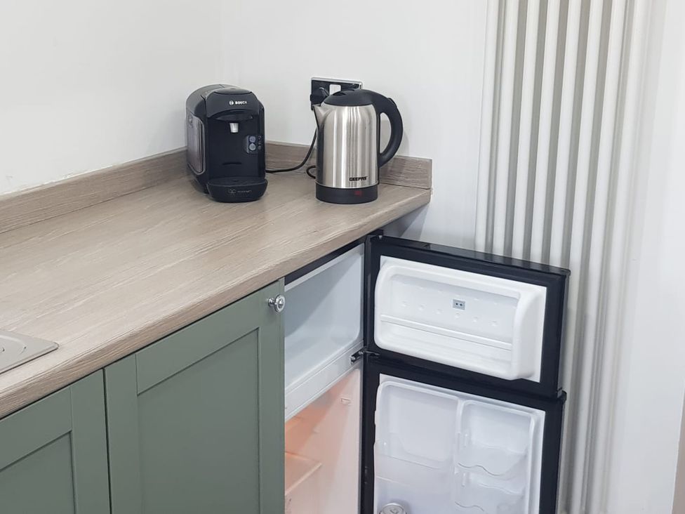 A kitchen with a coffee machine and kettle at Ehen Cottage in Cleator Moor