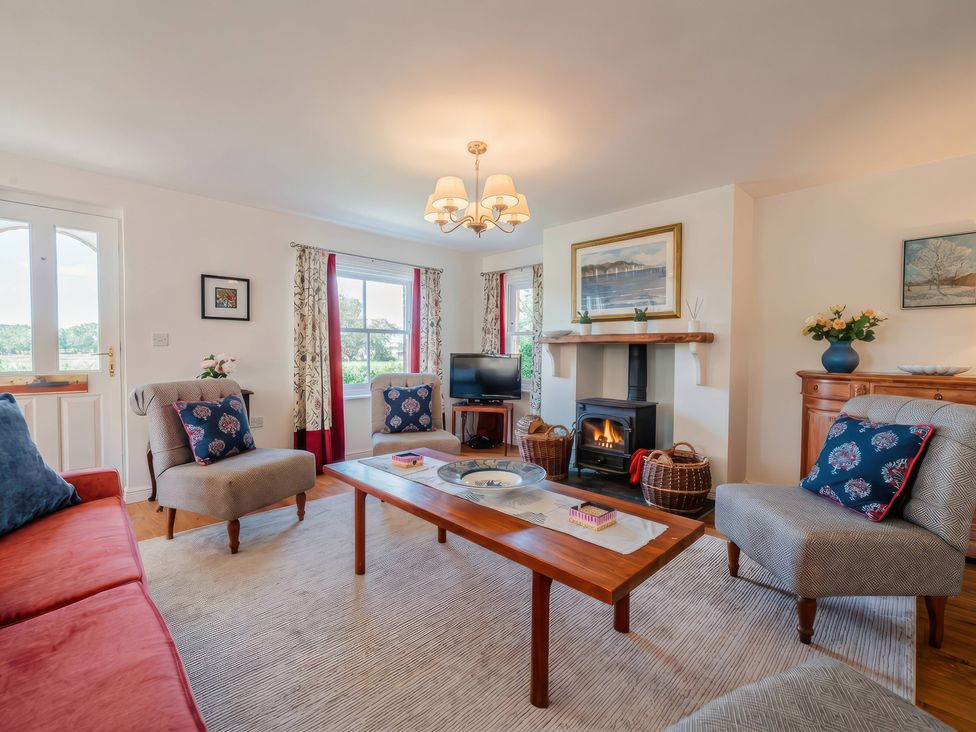 A living room with sofa chairs and coffee table at TBC