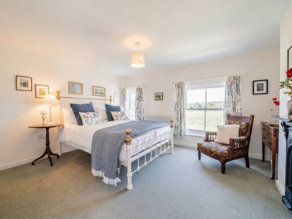 A bedroom with a bed and chair at TBC