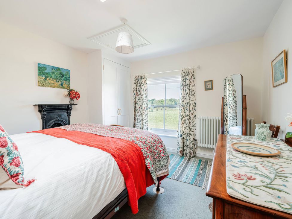 A bedroom with a bed, wardrobe, and window at TBC in 