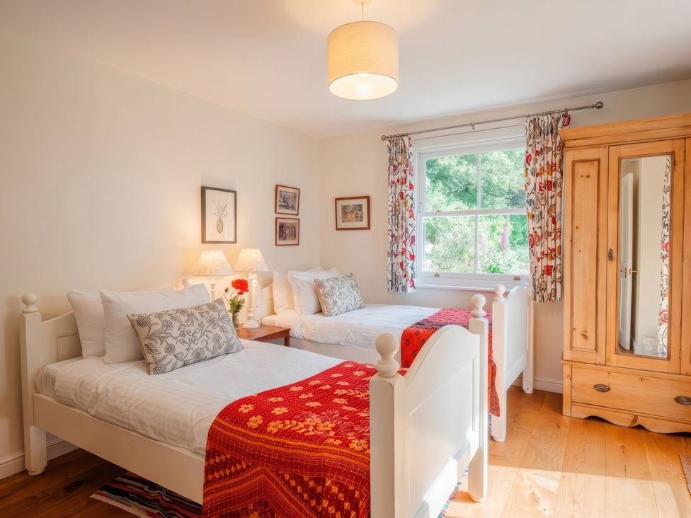 A bedroom with two beds and a wardrobe at TBC