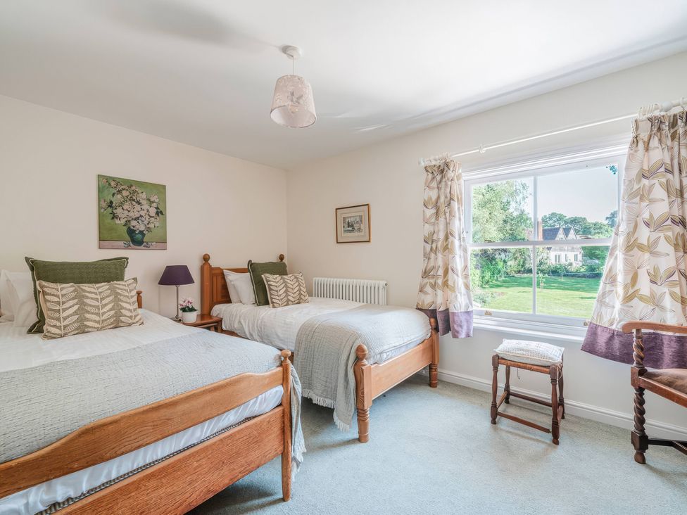 A bedroom with two beds and a view of the garden at TBC 