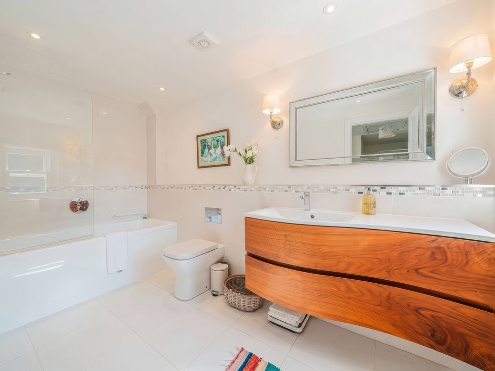 A bathroom featuring a bathtub, toilet, and vanity at TBC