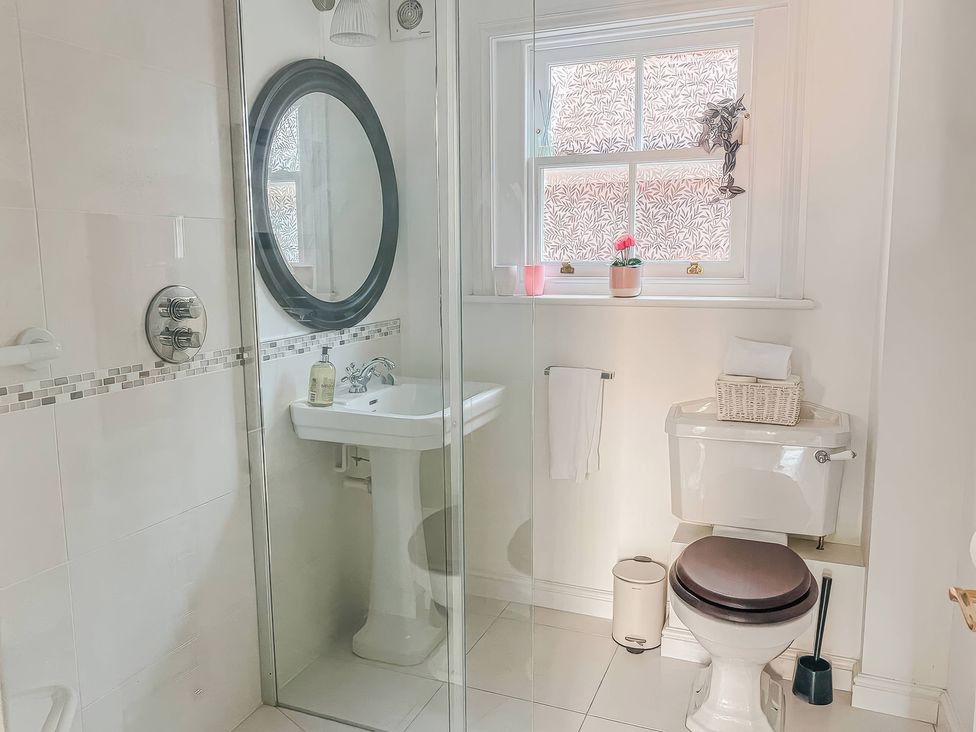A bathroom with a shower, sink, and toilet at TBC