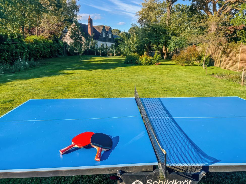 A table tennis table with paddles in a garden at TBC 