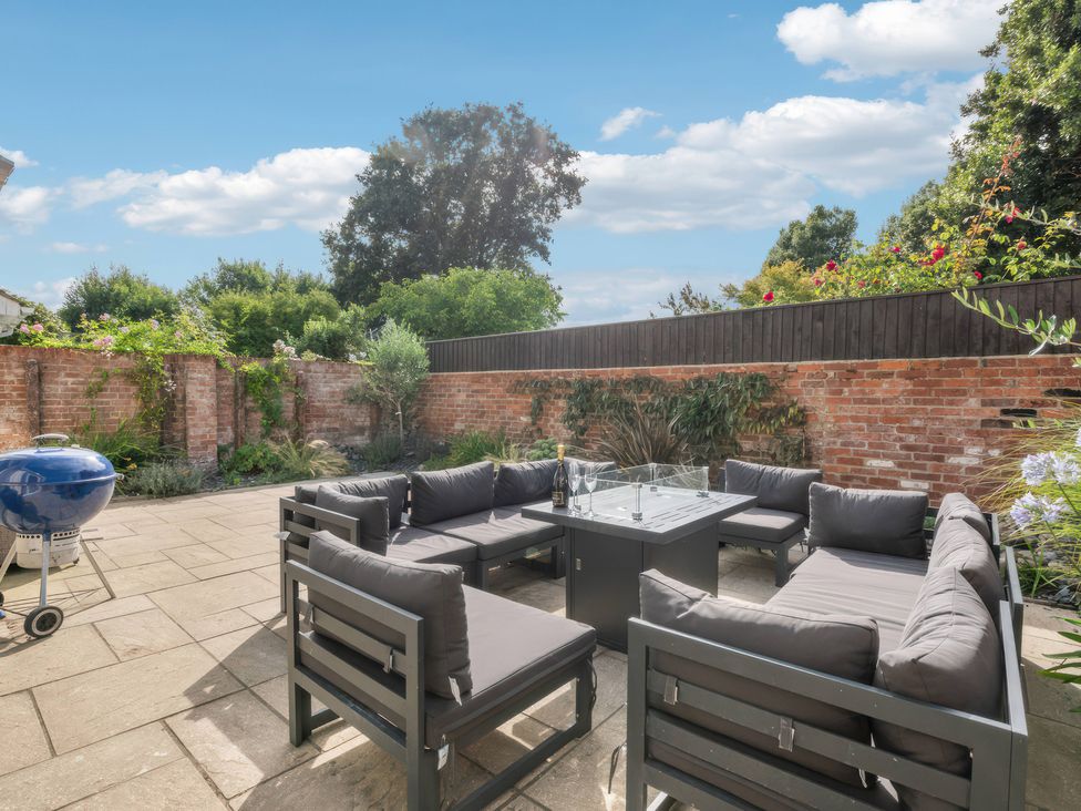 A garden with outdoor seating and a grill at TBC in 
