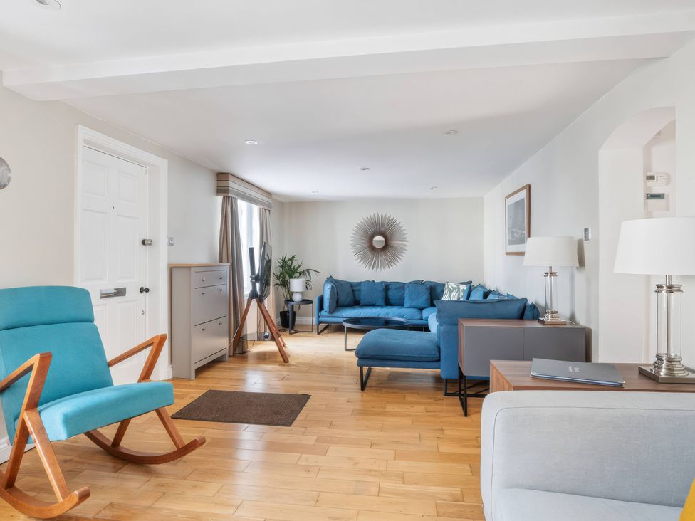 A living room with a blue sofa and an armchair at TBC in 