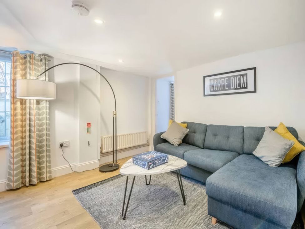 A living room with a sofa and floor lamp at TBC