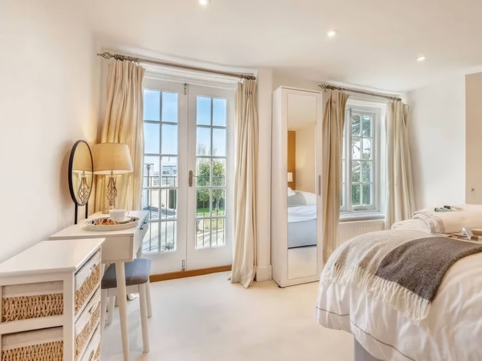 A bedroom with a bed, lamp, and a window at TBC